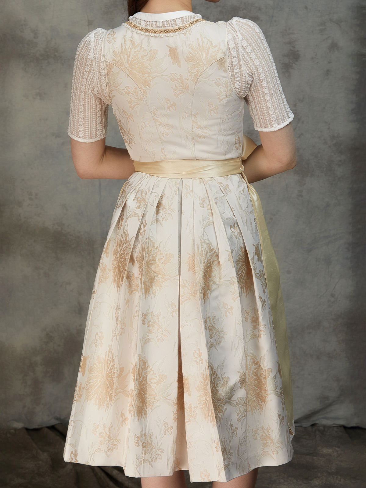 Ein elegantes gelbes Dirndl aus Samt mit floralen Details
